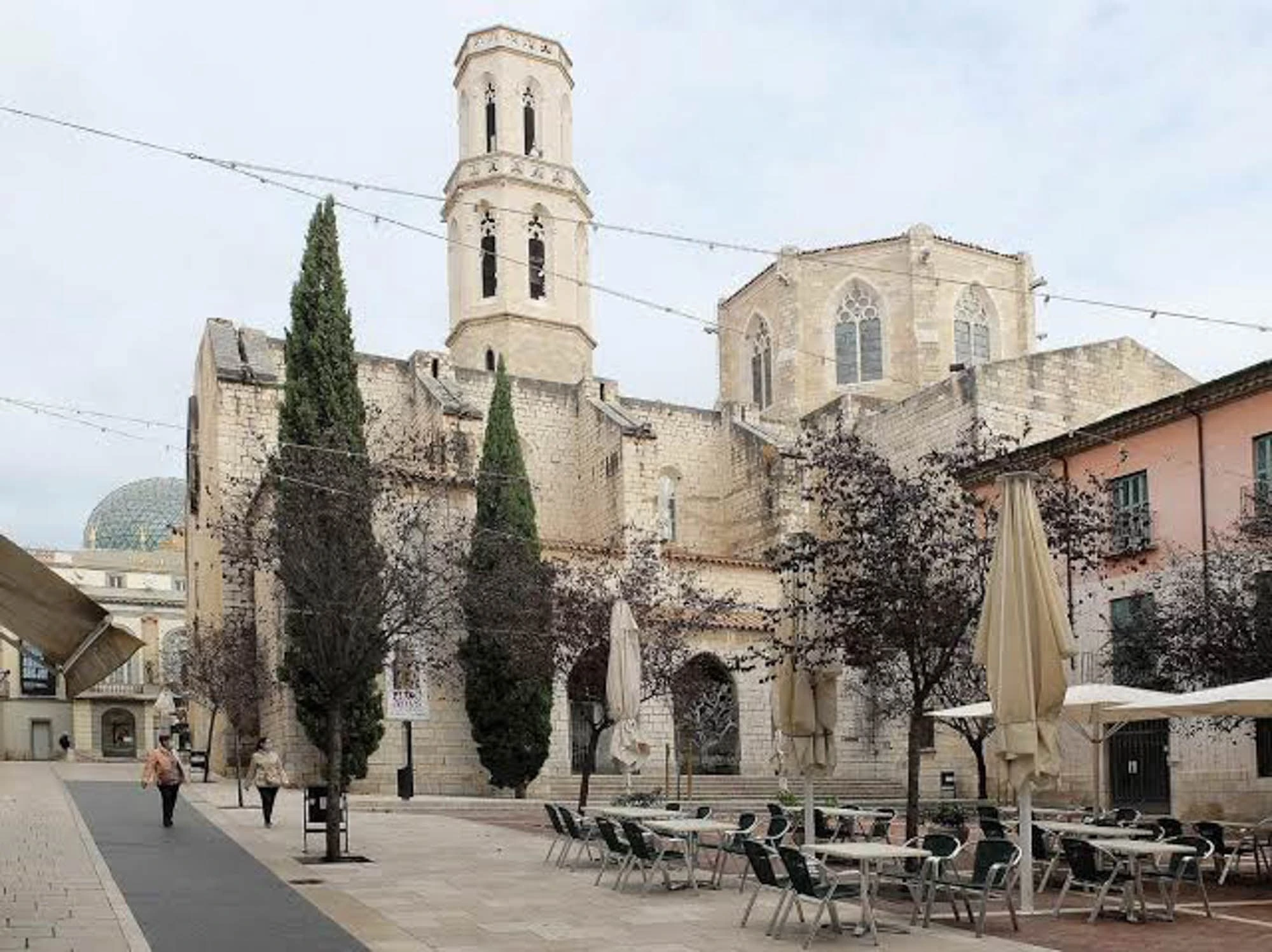 Rue du centre historique de Figueres avec les façades restaurées et l'Église Sant Pere au fond