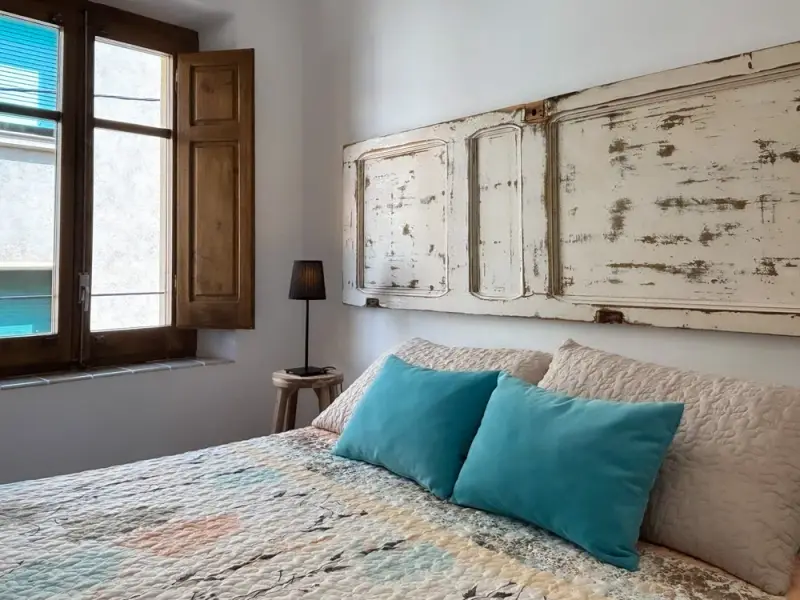 Habitació amb capçal fet amb una porta antiga